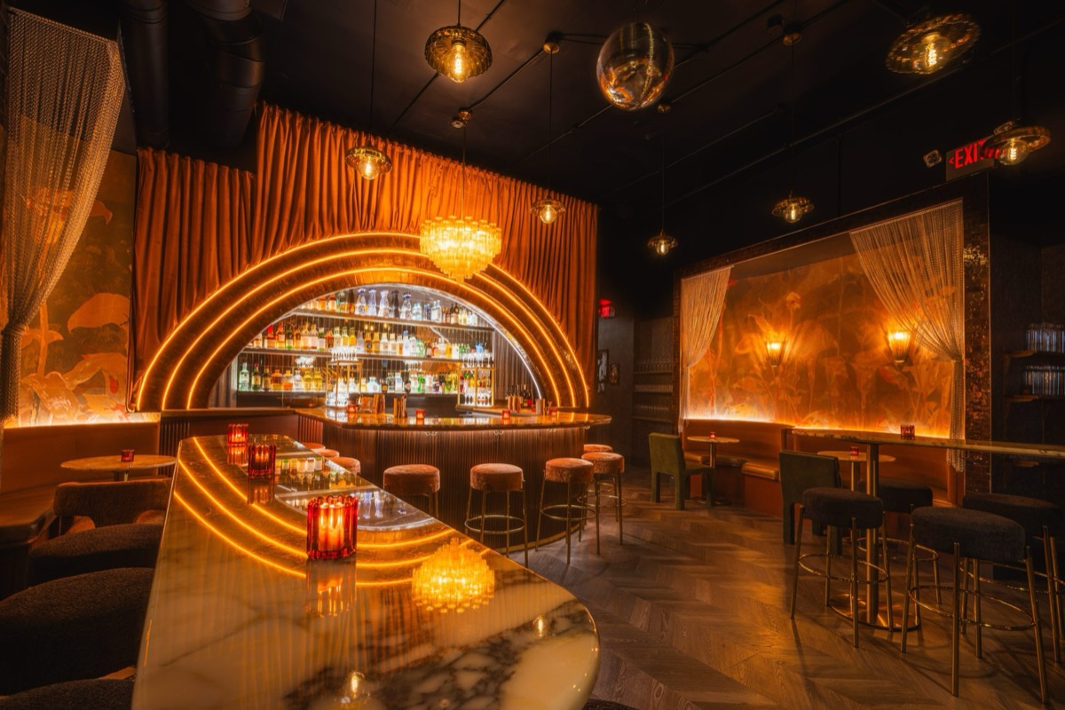 The Sweet Linda lounge in half-light — velvet seating, marble tables, warm lamps