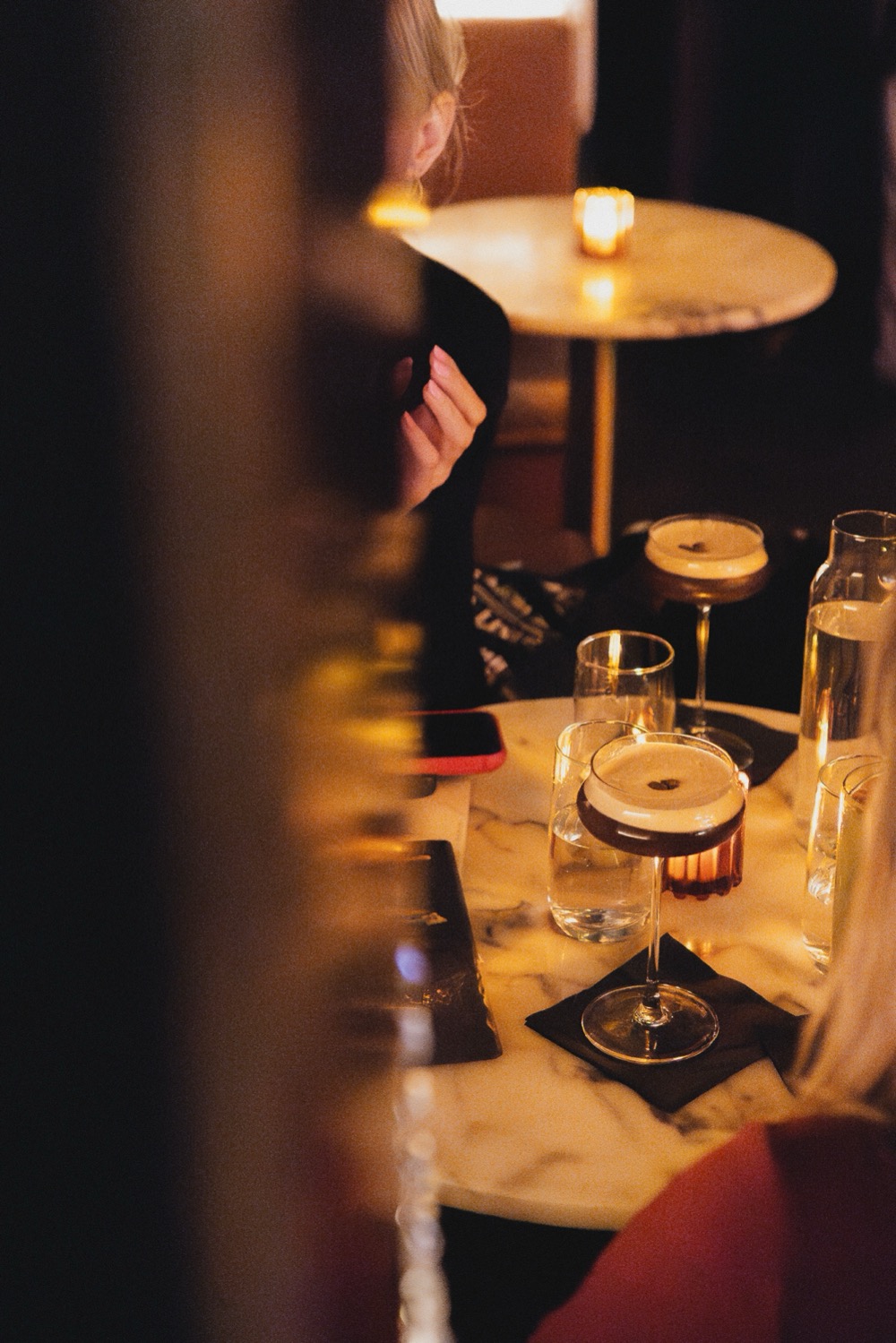Espresso martinis served on a marble table in candlelight